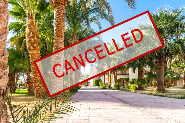 Crisis in the tourism industry due to outbreaks of coronavirus. Stopped traveling, red stamp text. Canceled text on a tropical beach with palm trees. Cancellation of a cruise due to the Covid-19