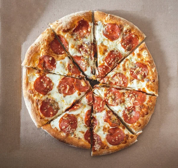 Pizza aux pepperoni hachés en morceaux dans une boîte de courtoisie. Concentration sélective. Vue d'en haut — Photo