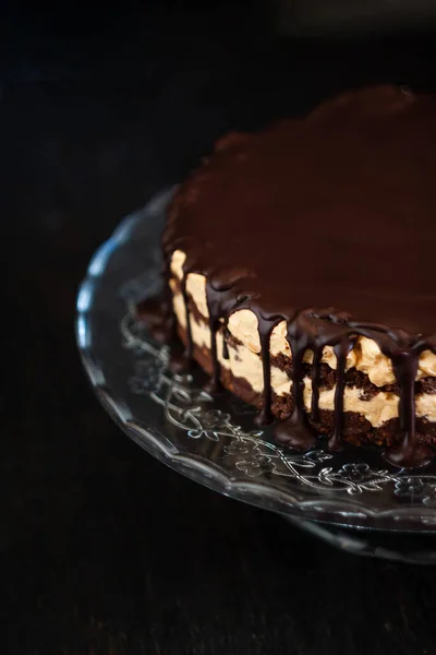 Шоколадні круглі шматочки торта з вершково-морозивом з шоколадними стрибками на скляній підставці на темному дерев'яному фоні. Мінімалізм, копіювання простору. Вибірковий фокус, крупним планом . — стокове фото