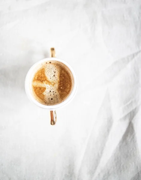 Xícara com café cappuccino em um fundo de tecido desleixado retro branco claro. Espaço para cópia. Deitado plano, vista superior. Minimalismo — Fotografia de Stock