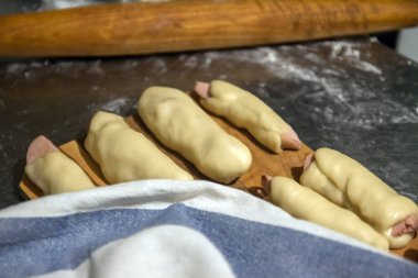 Peçetenin altındaki masada pişmeden önce testte çiğ sosisler hazırlandı. Konsept, ev yemeği