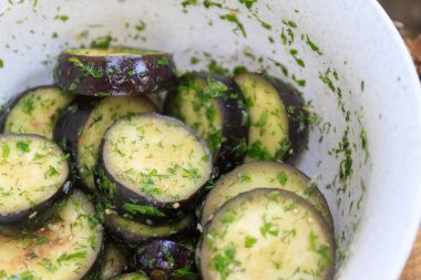 Bir kasede, çiğ, salamura edilmiş patlıcan, yabani otlarla kaplanmış, dereotlu, sade doğal bir şekilde. Izgara için hazırlık. Yukarıdan görüntüle.