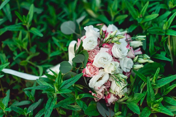 Весільний букет з білих і білих троянд в руках наречених — стокове фото