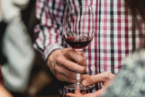 Hombre sostiene un vaso de vid en un bar — Foto de Stock