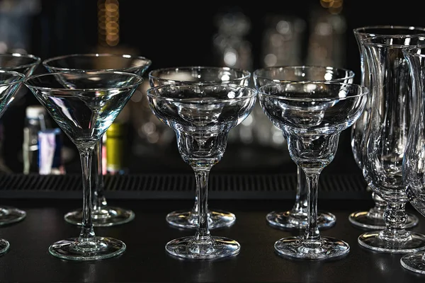 Vasos para una margarita, martini, grog y licor en un bar en el restaurante, contra el fondo de la pared del bar . —  Fotos de Stock