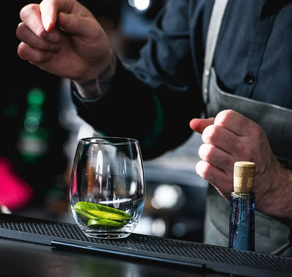 Camarero haciendo cóctel refrescante con pepino aislado sobre un fondo de barra — Foto de Stock