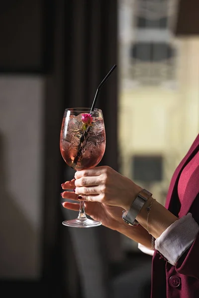 Woman holds relaxing alcoholic pink coctail with a rose on top — Stock Photo, Image