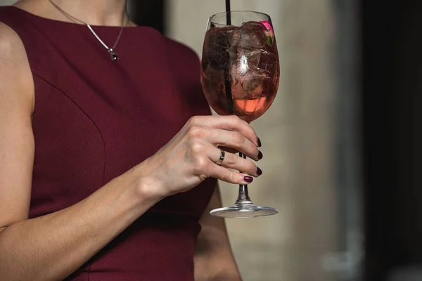 Woman holds relaxing alcoholic pink coctail with a rose on top — Stock Photo, Image