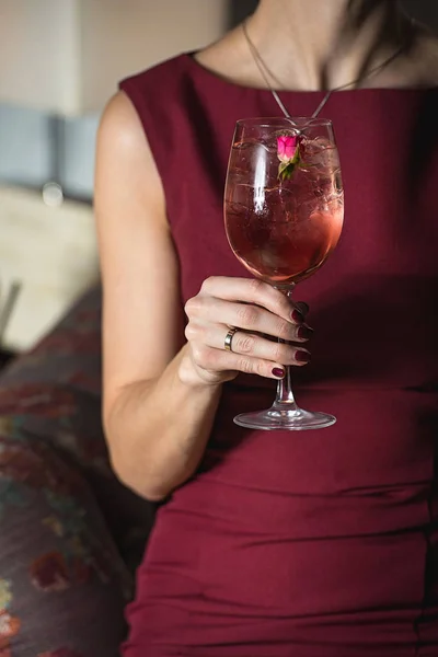 Woman holds relaxing alcoholic pink coctail with a rose on top — Stock Photo, Image