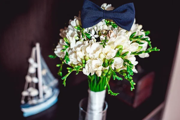 Corbata de lazo azul oscuro en un ramo de flores blancas de lujo en un estante — Foto de Stock