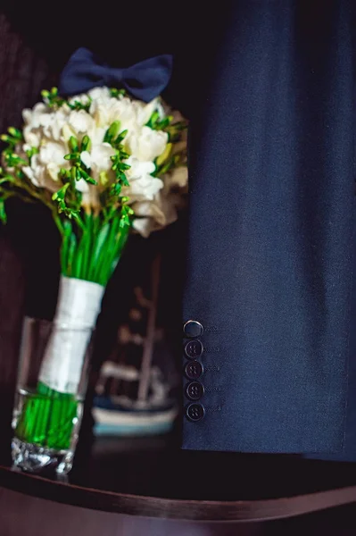 Σκούρο μπλε παπιγιόν σε μια πολυτελή νυφική ανθοδέσμη από λευκά άνθη σε ένα ράφι — Φωτογραφία Αρχείου