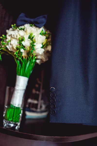 Corbata de lazo azul oscuro en un ramo de flores blancas de lujo en un estante — Foto de Stock