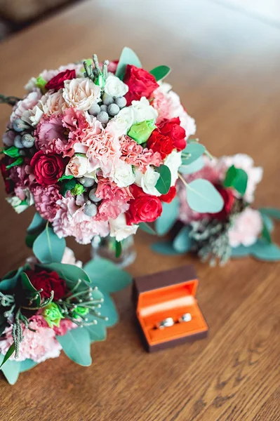 Buquê de casamento colorido com rosas e cravos na mesa ao lado de damas de honra Boutonniere e caixa com anéis — Fotografia de Stock