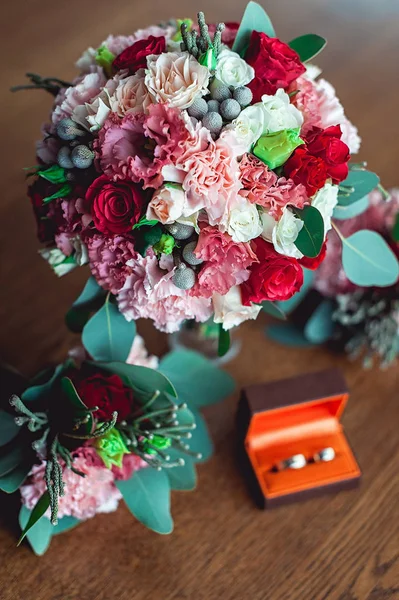 Buquê de casamento colorido com rosas e cravos na mesa ao lado de damas de honra Boutonniere e caixa com anéis — Fotografia de Stock