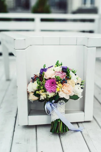 Buquê de noiva de diferentes flores envolto fita de renda em um fundo branco — Fotografia de Stock