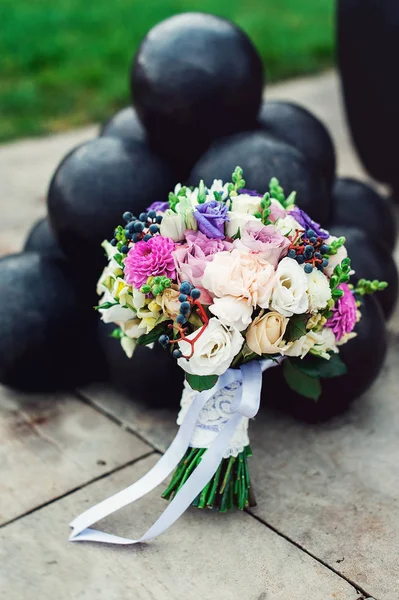Buquê de noiva de diferentes flores envolto fita de renda perto de bando de canhões — Fotografia de Stock