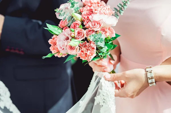 Vrouw in een jurk bedrijf bruiloft boeketten van wit en biege rozen — Stockfoto