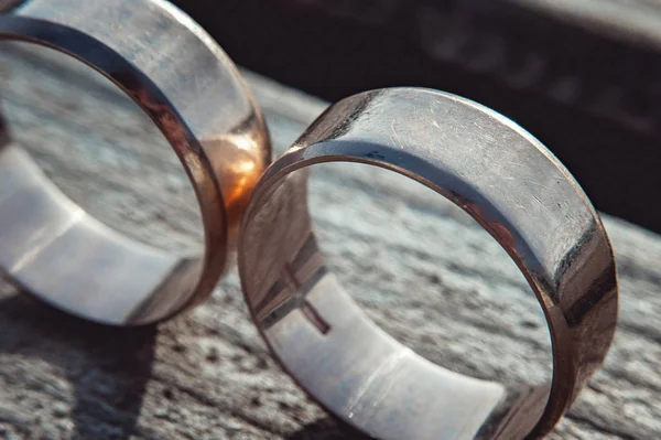 Rayado dos anchos anillos de boda de oro en la superficie de piedra — Foto de Stock