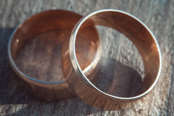 Riscado dois anéis de casamento de ouro largos na superfície de pedra — Fotografia de Stock