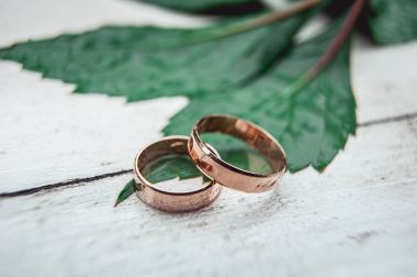 Beyaz ahşap bir masa üzerinde iki altın alyans