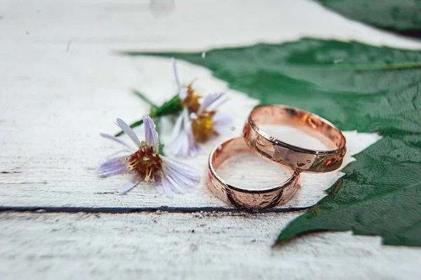 Dos anillos de boda dorados en una mesa de madera blanca — Foto de Stock