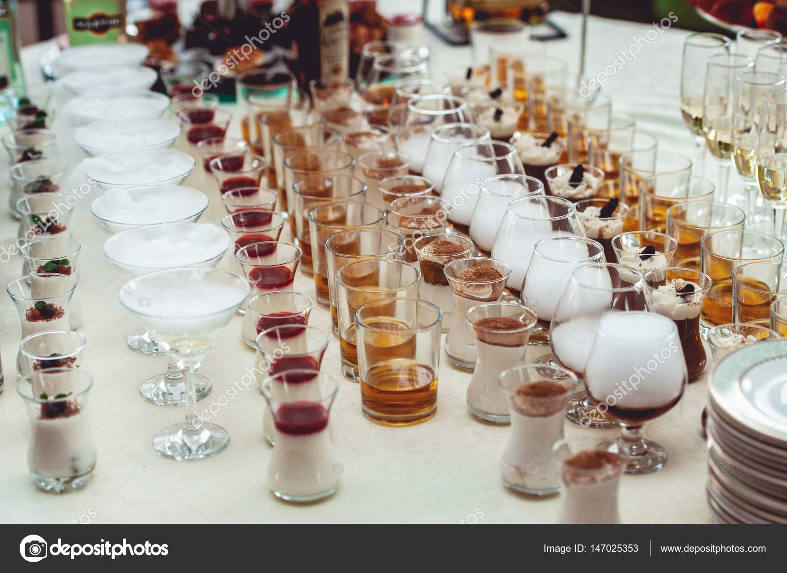 Beautiful row line of different colored alcohol cocktails on a party