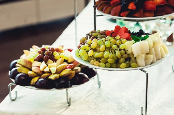 Gerechten met vers fruit op een stand — Stockfoto