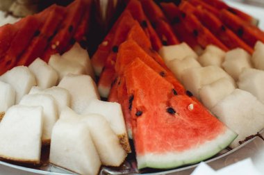 karpuz ve malon ahşap bir masaya dilimlenmiş