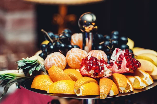 Gesneden fruit op een stand op een witte tafel — Stockfoto