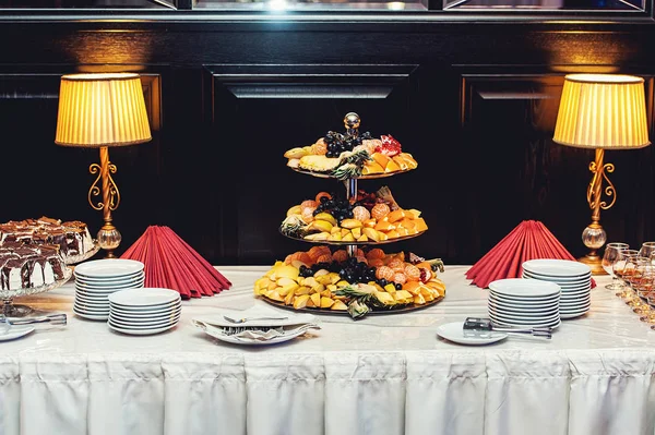 Salle de restaurant vintage, mur en bois. fruits et pâtisseries sur des stands vintage blancs — Photo