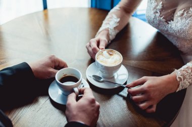 Gelin ve damat yuvarlak ahşap masa, bir kafede kahve içme