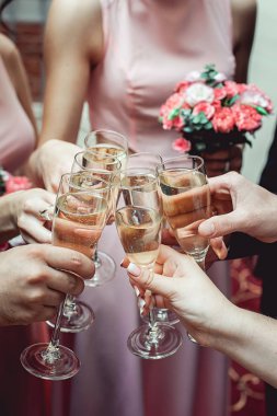 İnsanlar beyaz şarapla el ele tutuşuyorlar. düğün partisi.