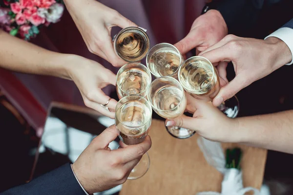 As pessoas seguram em copos de mãos com vinho branco. festa de casamento. — Fotografia de Stock