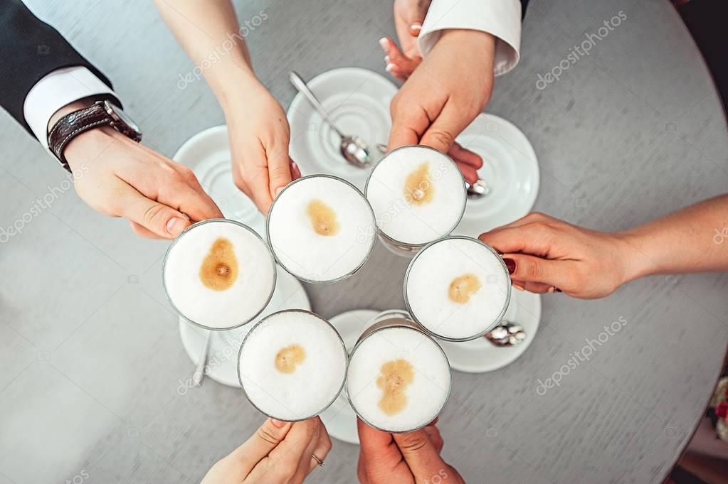 People hold in hands cups with coffe
