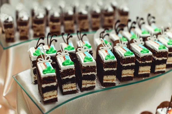 Ряды различных десертных тортов на шоколадке — стоковое фото