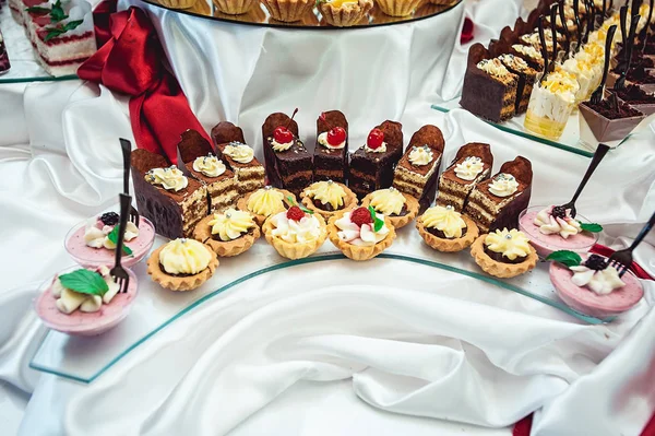 Sorok különböző sütemény, egy üveg stand — Stock Fotó