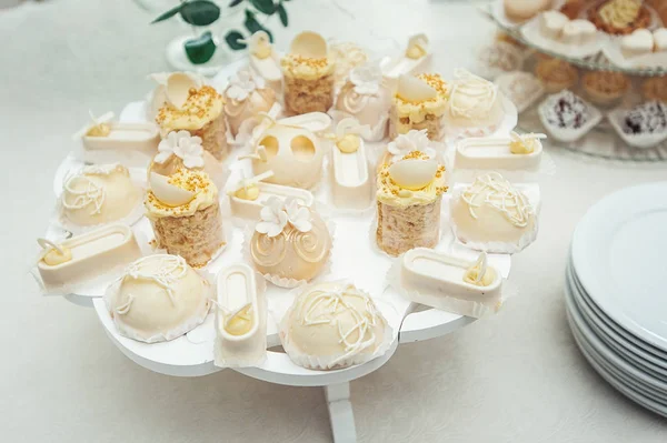 Bolos brancos e cupcakes no prato branco vintage — Fotografia de Stock