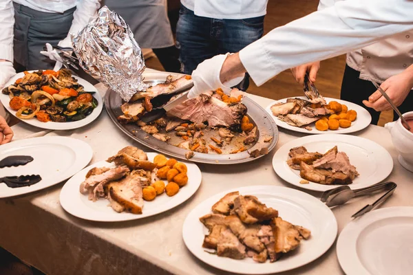 Chef corta carne assada para convidados do restaurante — Fotografia de Stock