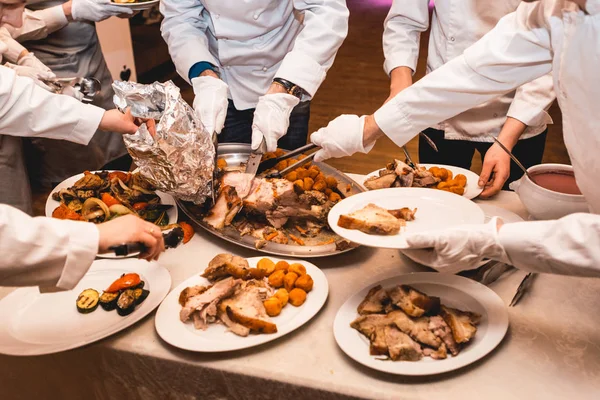 Chef corta carne assada para convidados do restaurante — Fotografia de Stock