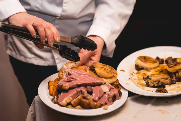 chef cuts roasted meat for restaurant guests