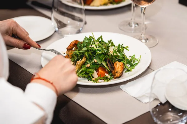Женщина ест вкусный салат с креветками в ресторане — стоковое фото