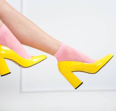 Pembe çorap ve sarı ayakkabı erotik bacaklarda. Genç seksi kadın bacaklar beyaz bir arka plan üzerinde