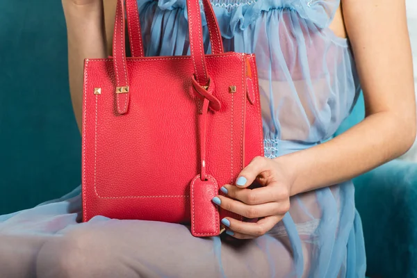 Sexy girl in a blue nightgown holds red handbag — Stock Photo, Image