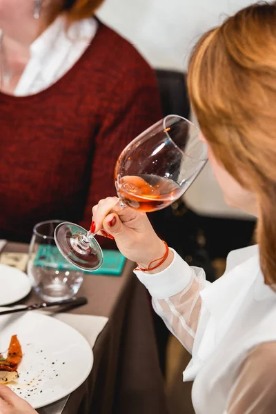 Mujer bebiendo vino en una cata de vinos en un restaurante — Foto de Stock
