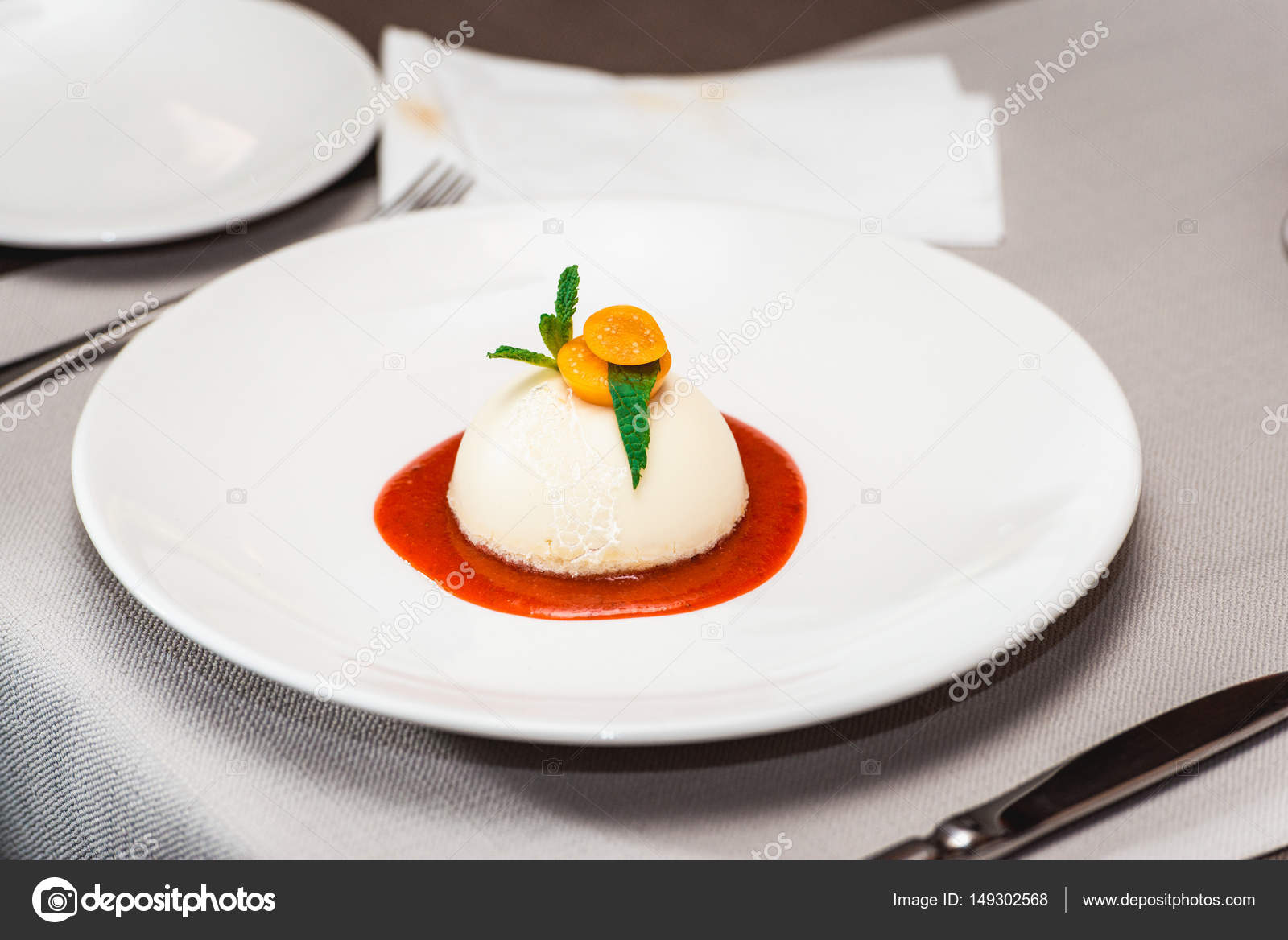 Mini round cheesecake with strawberry jam on a plate in the expensive