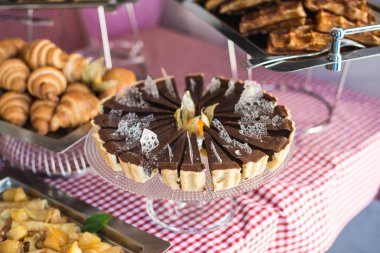 bir cam stand yuvarlak çikolatalı kek. Tablo içinde bir restoran