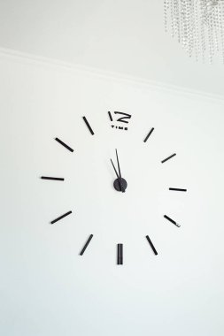 Beyaz beton duvara çerçevesiz duvar saati. Minimalizm