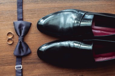 Siyah papyon deri ayakkabı ve kemer önce yatıyor. Düğün sabah mamülleri