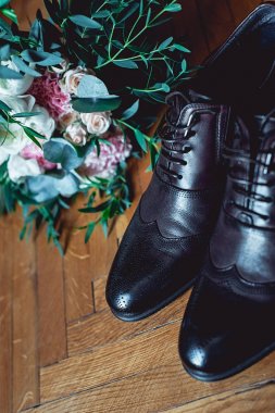 Modern insan aksesuarları, yakın çekim. Siyah papyon, deri ayakkabı, kemer ve düğün buket ahşap rustik arka plan üzerinde. Eşyası resmi stil kümesi