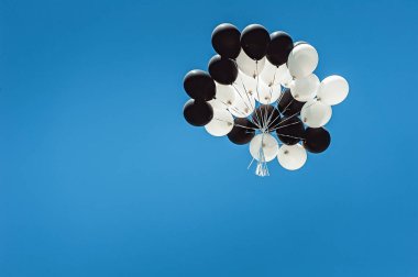 siyah ve beyaz balonlar gökyüzünde yüksek kümesi. Bulutsuz mavi gökyüzü